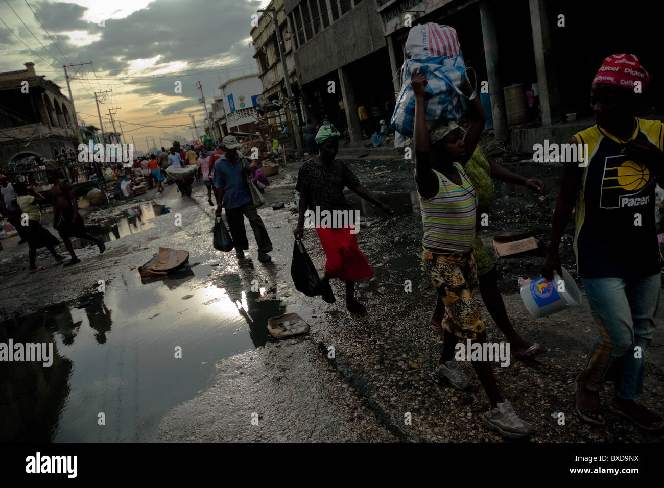 Les femmes haïtiennes mener des vivres pendant la tombée dans le marché de la saline, Port-au-Prince, Haïti. Banque D'Images