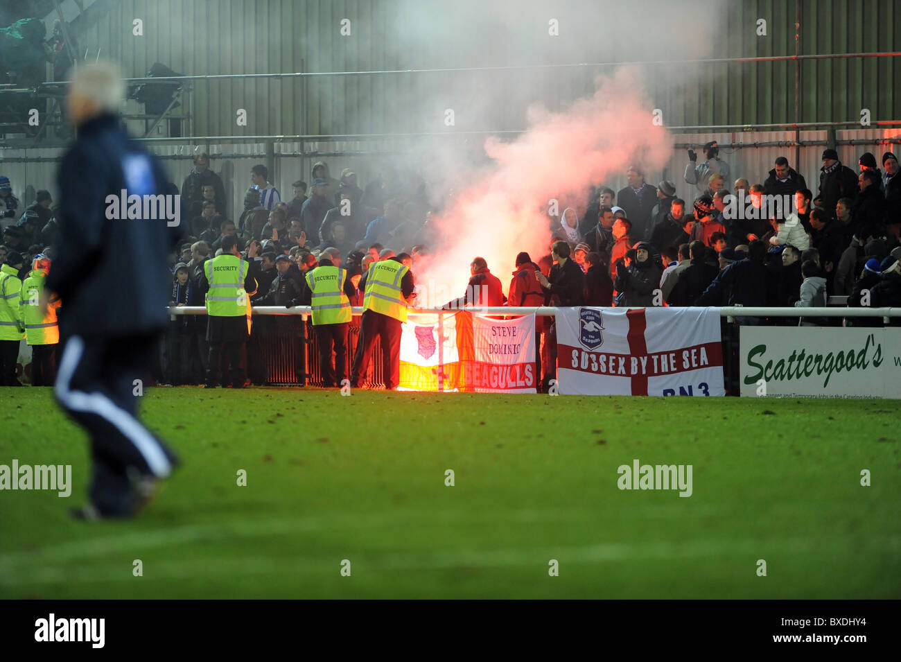 Le club de football de Woking, stewards se précipiter au loin fans après que l'un d'eux vous permet de désactiver une poussée après le match terminé Banque D'Images