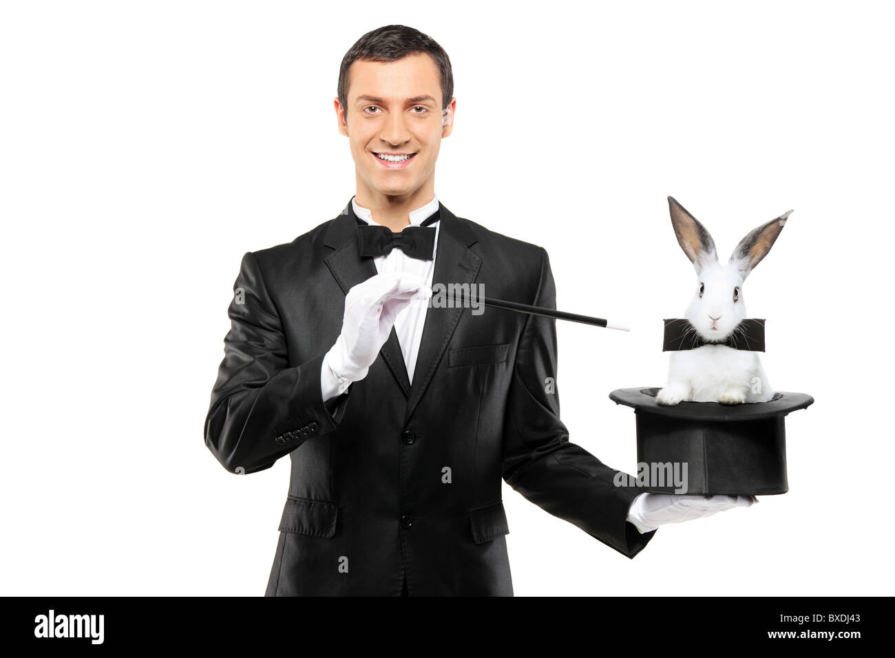 Un magicien dans un costume noir tenant un haut chapeau avec un lapin dans c Banque D'Images