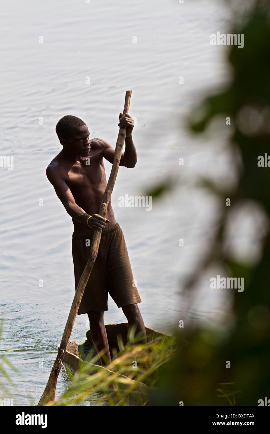 Le pêcheur local polonais sa pirogue le long de la rive de la rivière Zambèze à Livingstone (Zambie). Banque D'Images