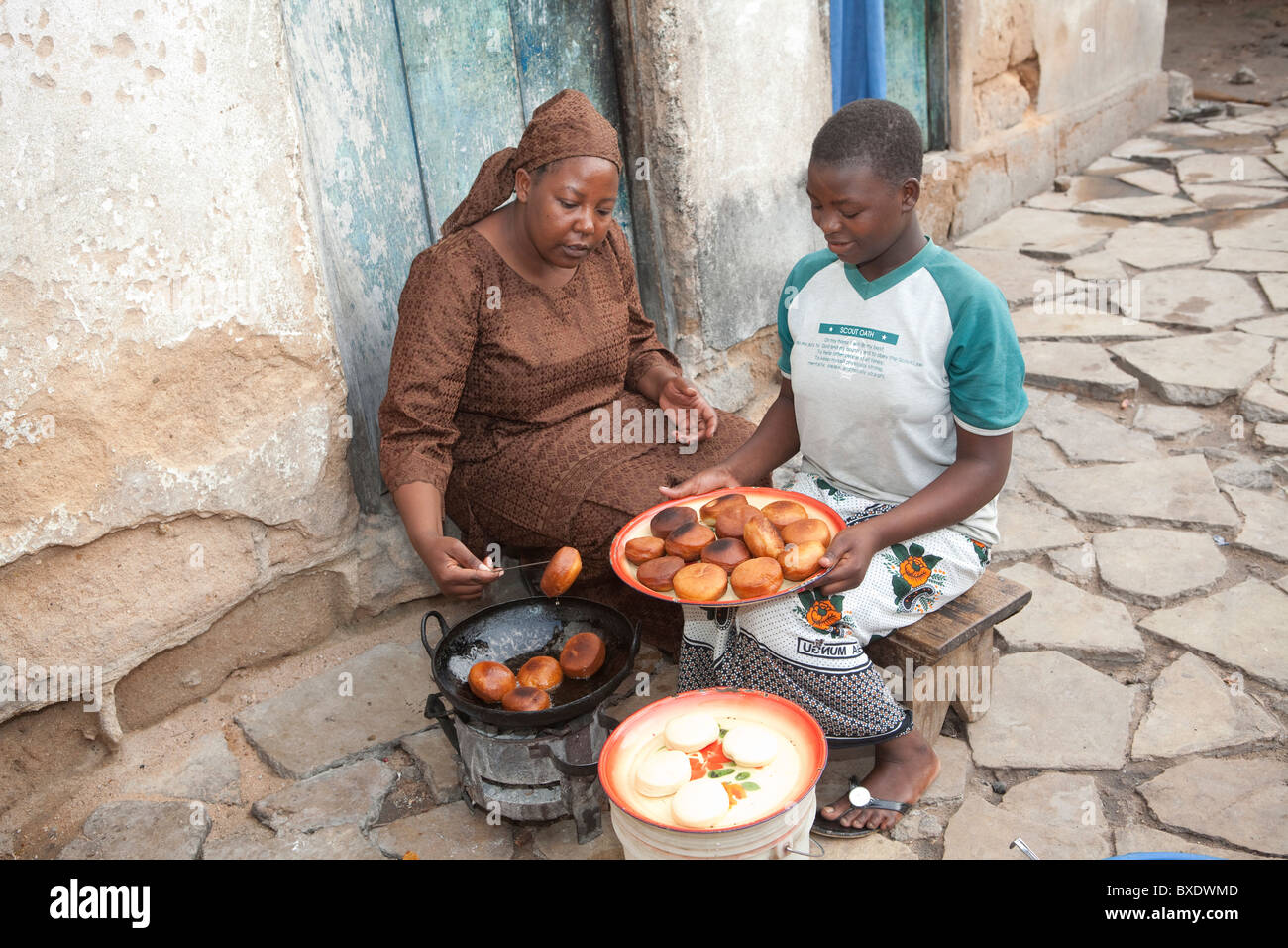 Une jeune femme cuisiniers mandazi (beignets) dans les rues de Dodoma, Tanzanie, Afrique de l'Est. Banque D'Images