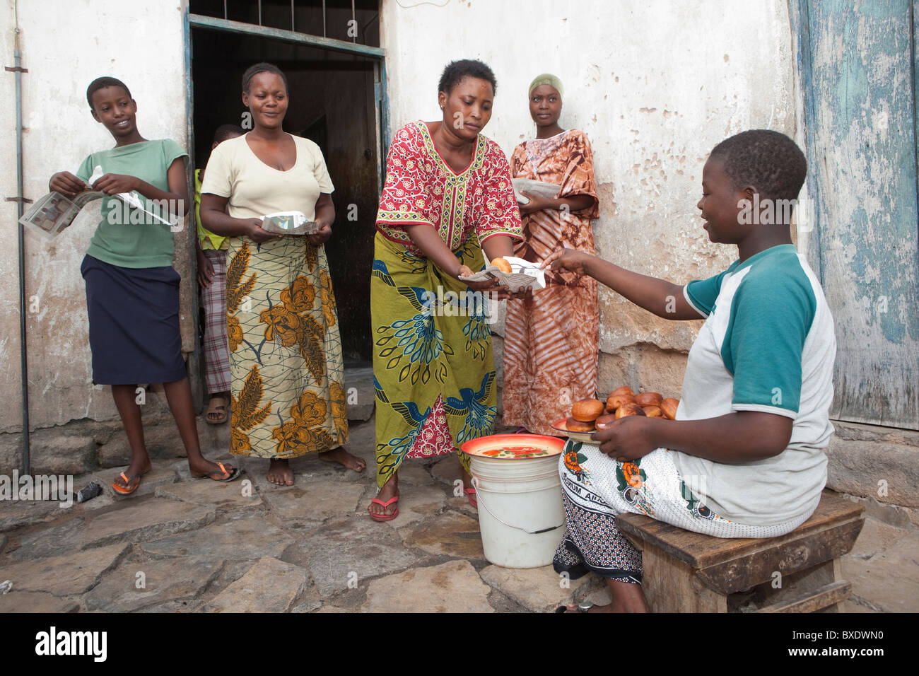 Une jeune femme vend mandazi (beignets) dans les rues de Dodoma, Tanzanie, Afrique de l'Est. Banque D'Images