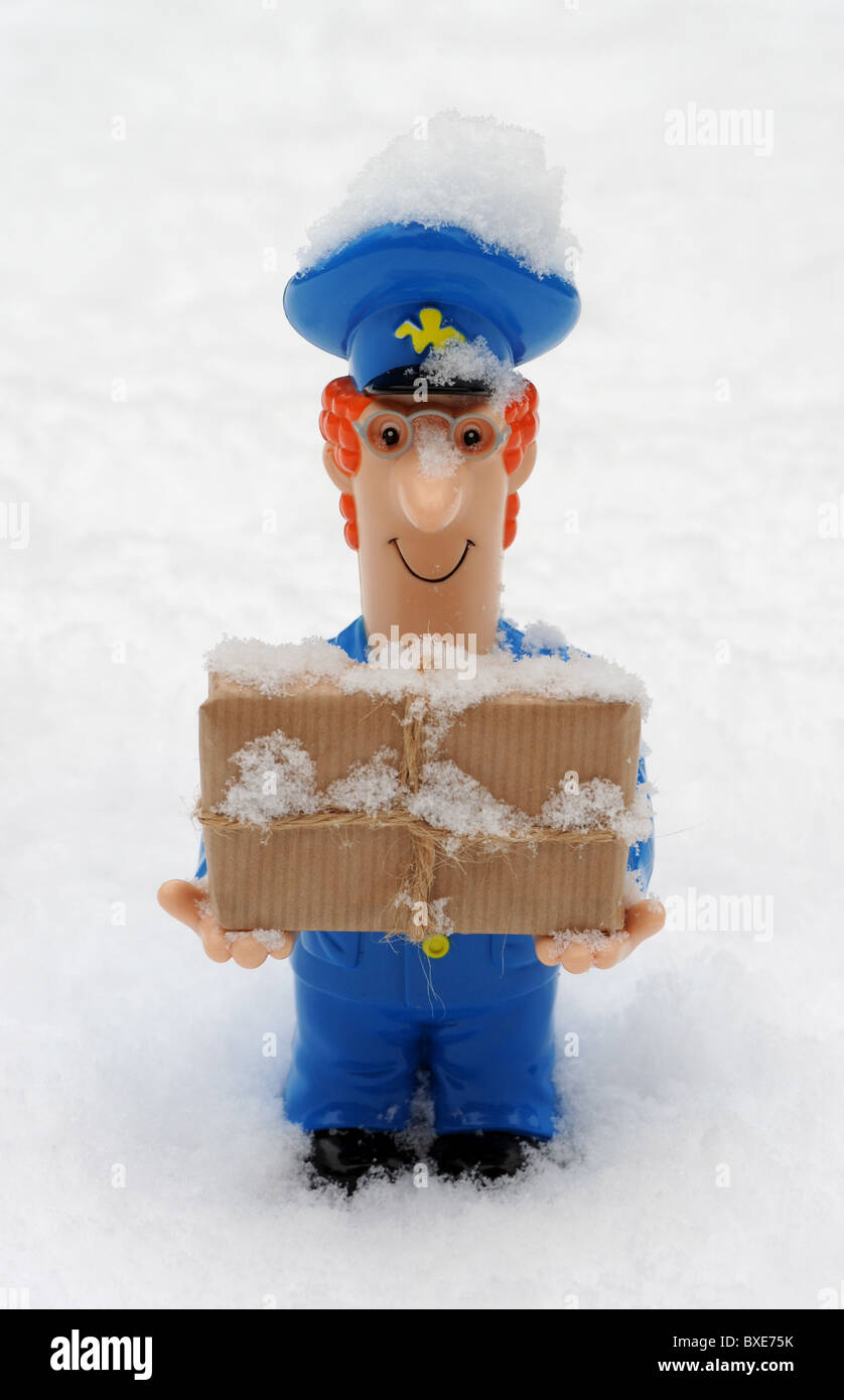 POSTMAN FIGURE AVEC COLIS DANS DES CONDITIONS MÉTÉOROLOGIQUES GLACIALES ENNEIGÉS DU BUREAU DE POSTE DE NOUVEAU DES RETARDS DE LIVRAISONS HIVER ETC UK POSTAL SERVICE Banque D'Images