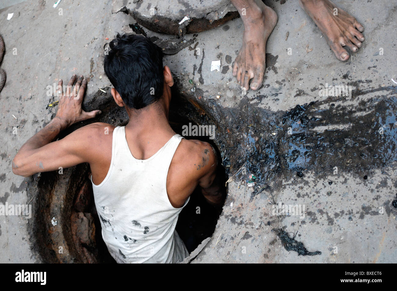 Un homme nettoie les égouts, Delhi. Ce travail est traditionnellement effectué par les dalits, ou "intouchables", le plus faible du système des castes essorée. Banque D'Images