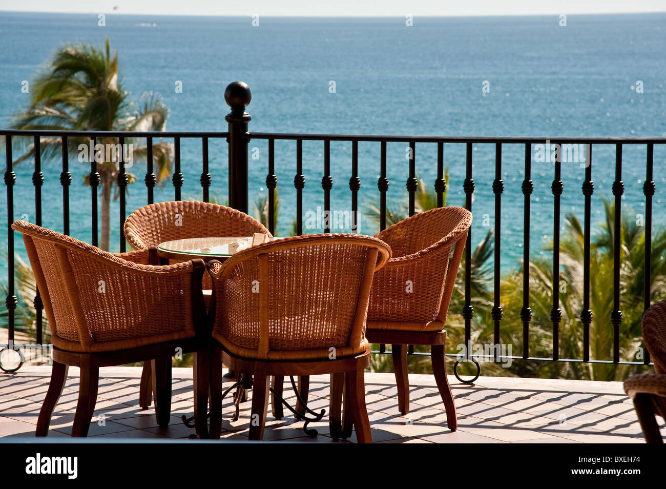 Une petite table avec quatre chaises sur un pont en plein air plus de voir un océan tropical Banque D'Images