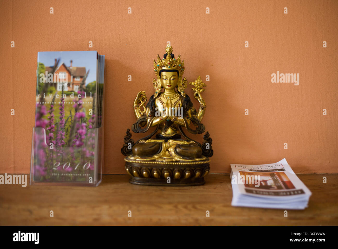 L'icône de Bouddha et des brochures sur la corniche au centre de retraite bouddhiste Rivendell, East Sussex, Angleterre. Banque D'Images