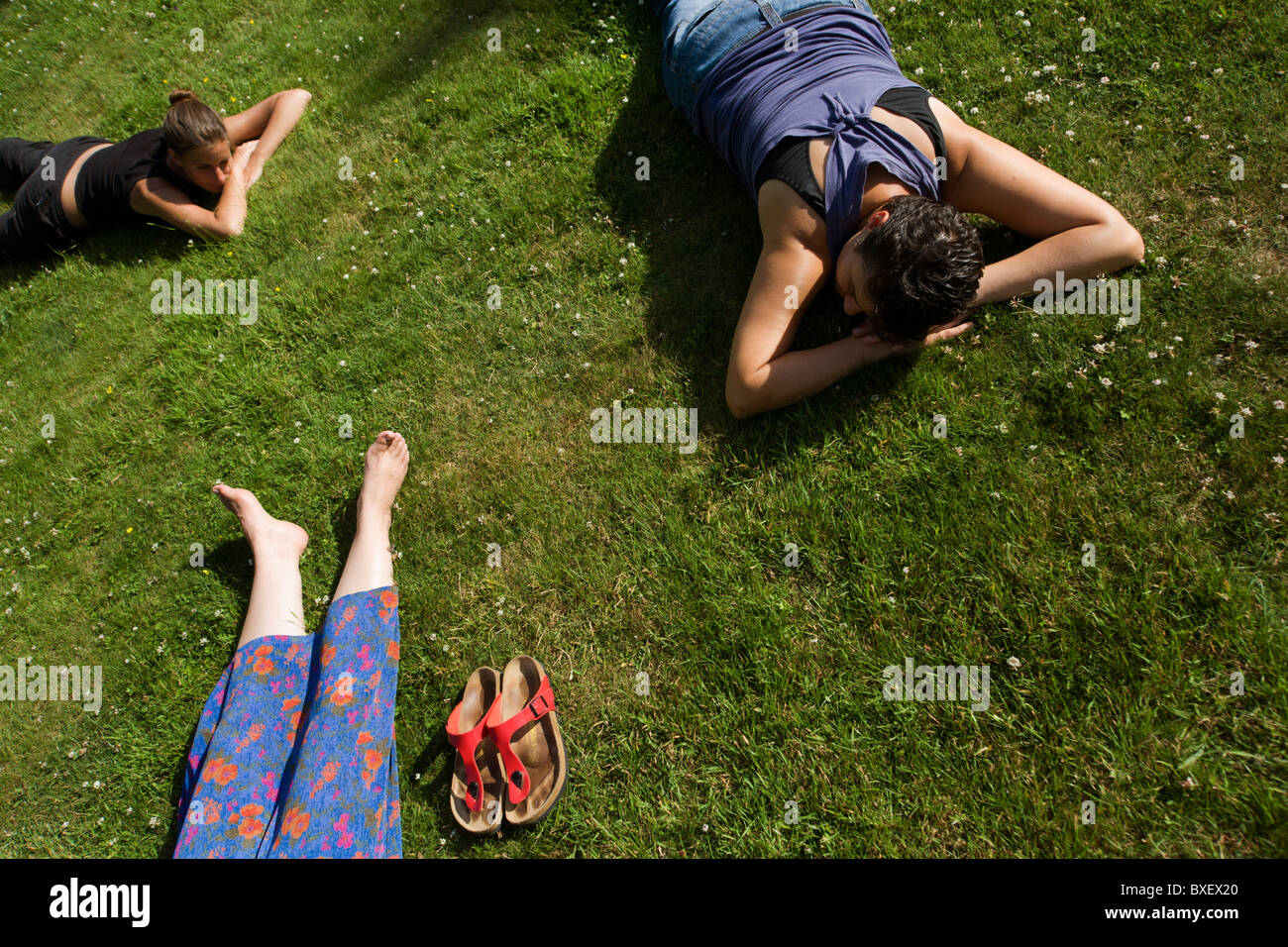 Les bénévoles de somnoler sur pelouse après longue journée de travail au centre de retraite bouddhiste Rivendell, East Sussex, Angleterre. Banque D'Images