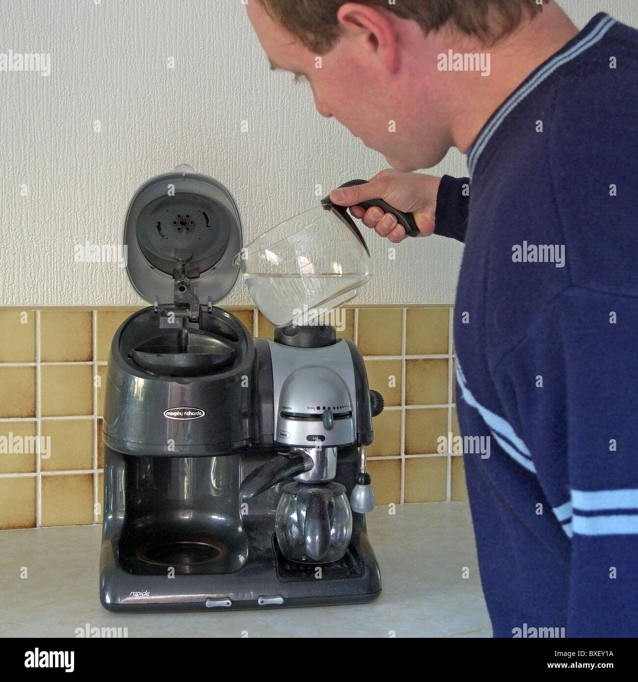 Mâle adulte de race blanche verser de l'eau dans un Morphy Richards  Cafetière et machine à expresso PARUTION MODÈLE Photo Stock - Alamy