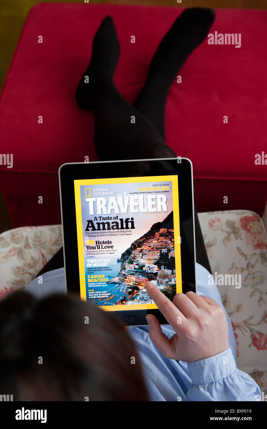Femme lisant le National Geographic Traveler Magazine de voyage en ligne application sur un iPad tablet computer Banque D'Images