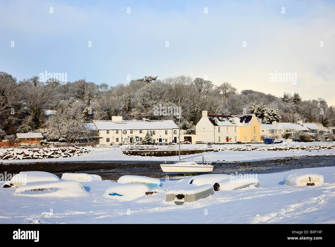 Village neige scène avec le bateau sur l'autre en décembre 2010 de l'AONB en hiver. Quai rouge Bay (Traeth Coch) Isle of Anglesey au nord du Pays de Galles Royaume-uni Grande-Bretagne Banque D'Images