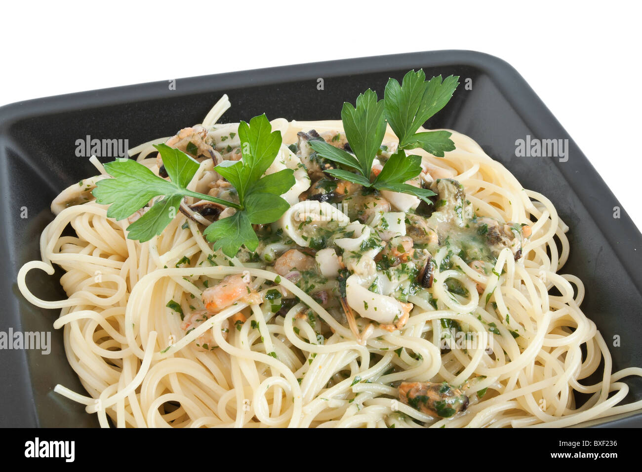 Spaghetti aux crevettes, calamars, moules et persil isolated on white Banque D'Images