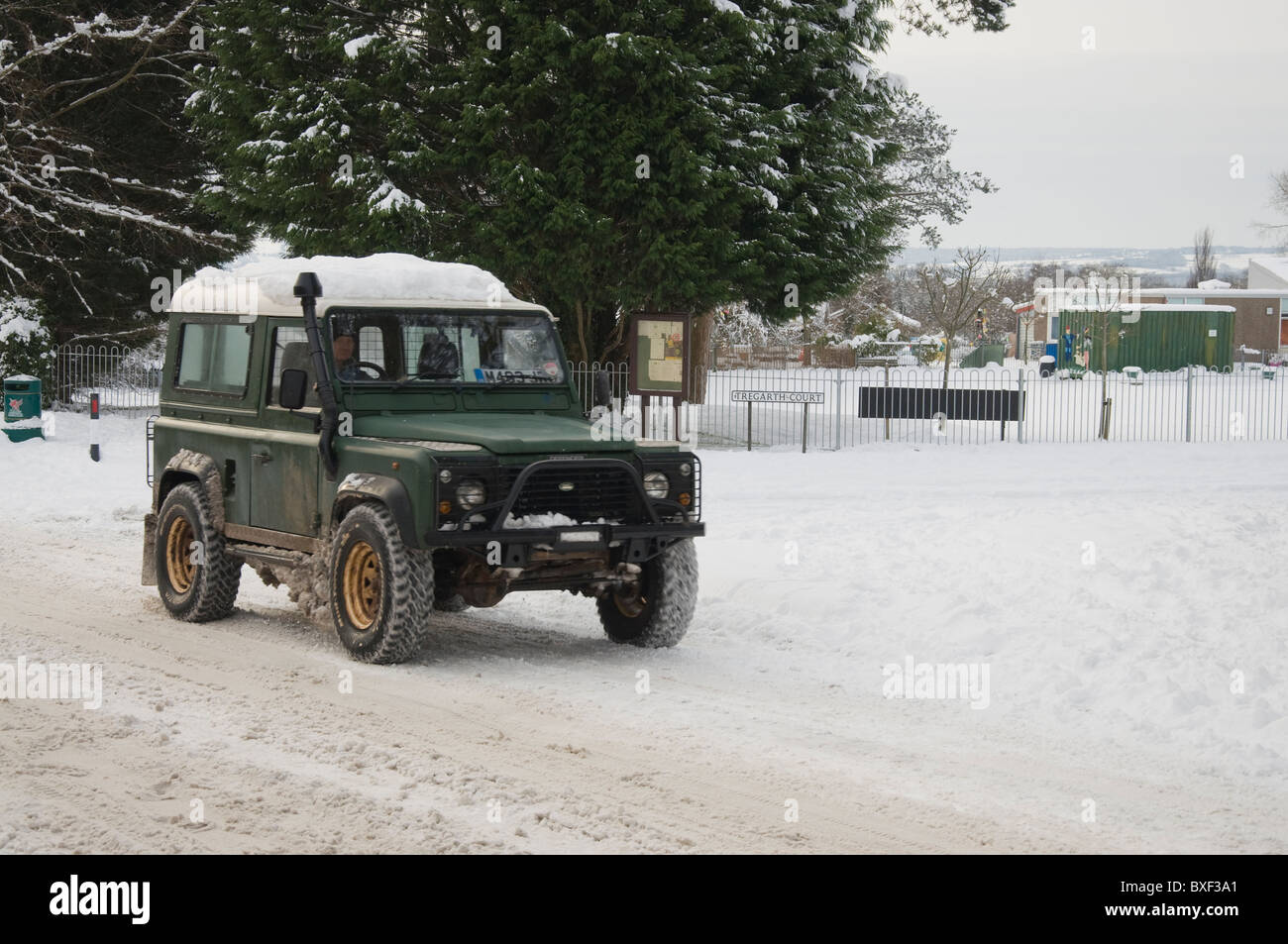 Un véhicule à 4 roues motrices de la conduite dans la neige un village rural dans le pays de Galles lié Banque D'Images