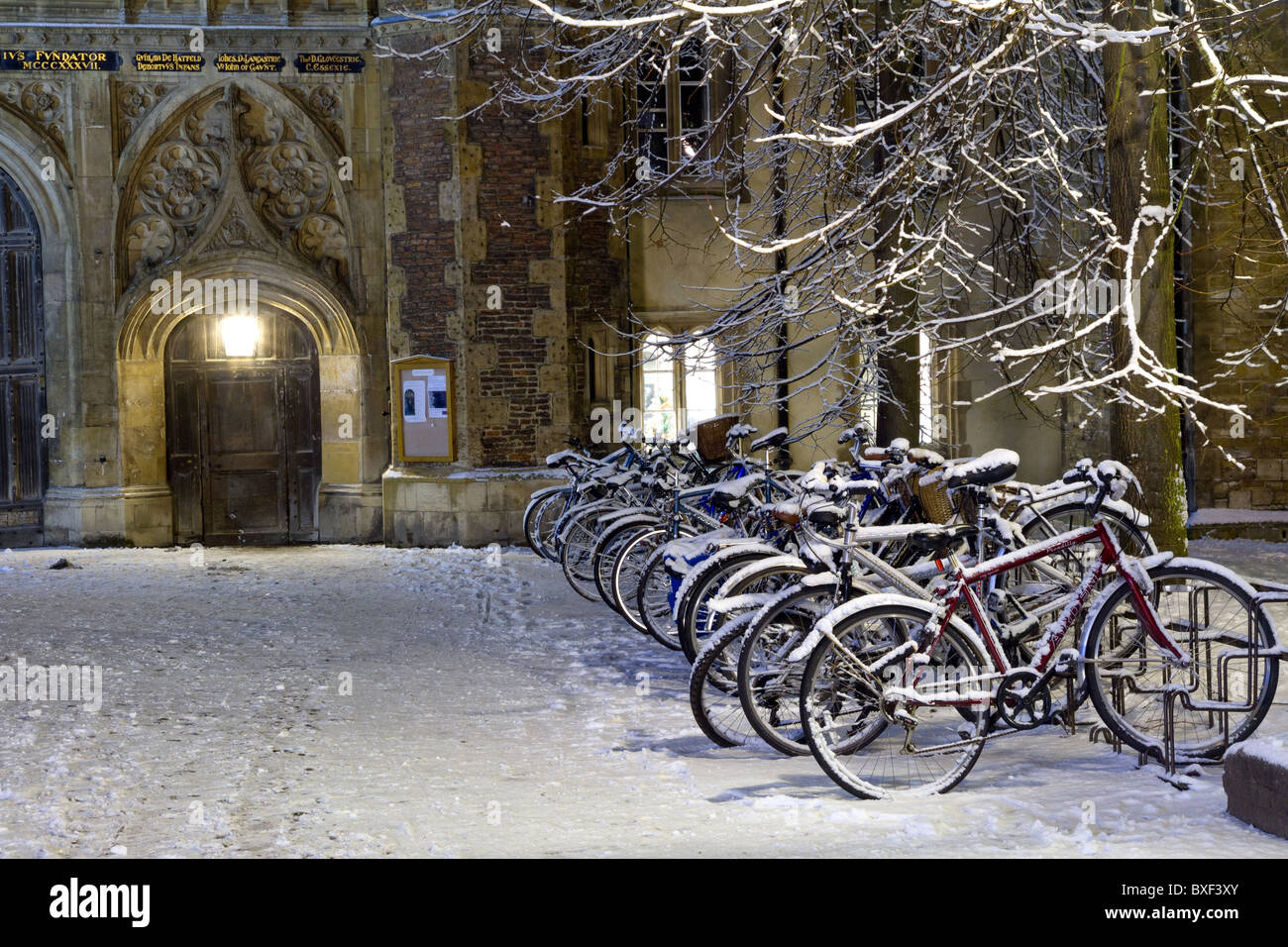 Les vélos sont garés dans la neige à l'extérieur de St John's College de Cambridge Banque D'Images