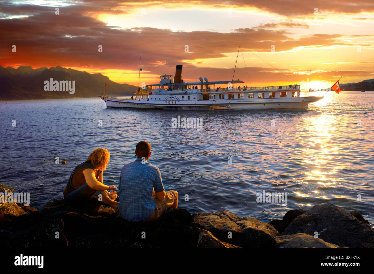 Jeune couple watching un ferry au coucher du soleil sur le Lac Léman (Lac de Genève) - Montraux Suisse Banque D'Images