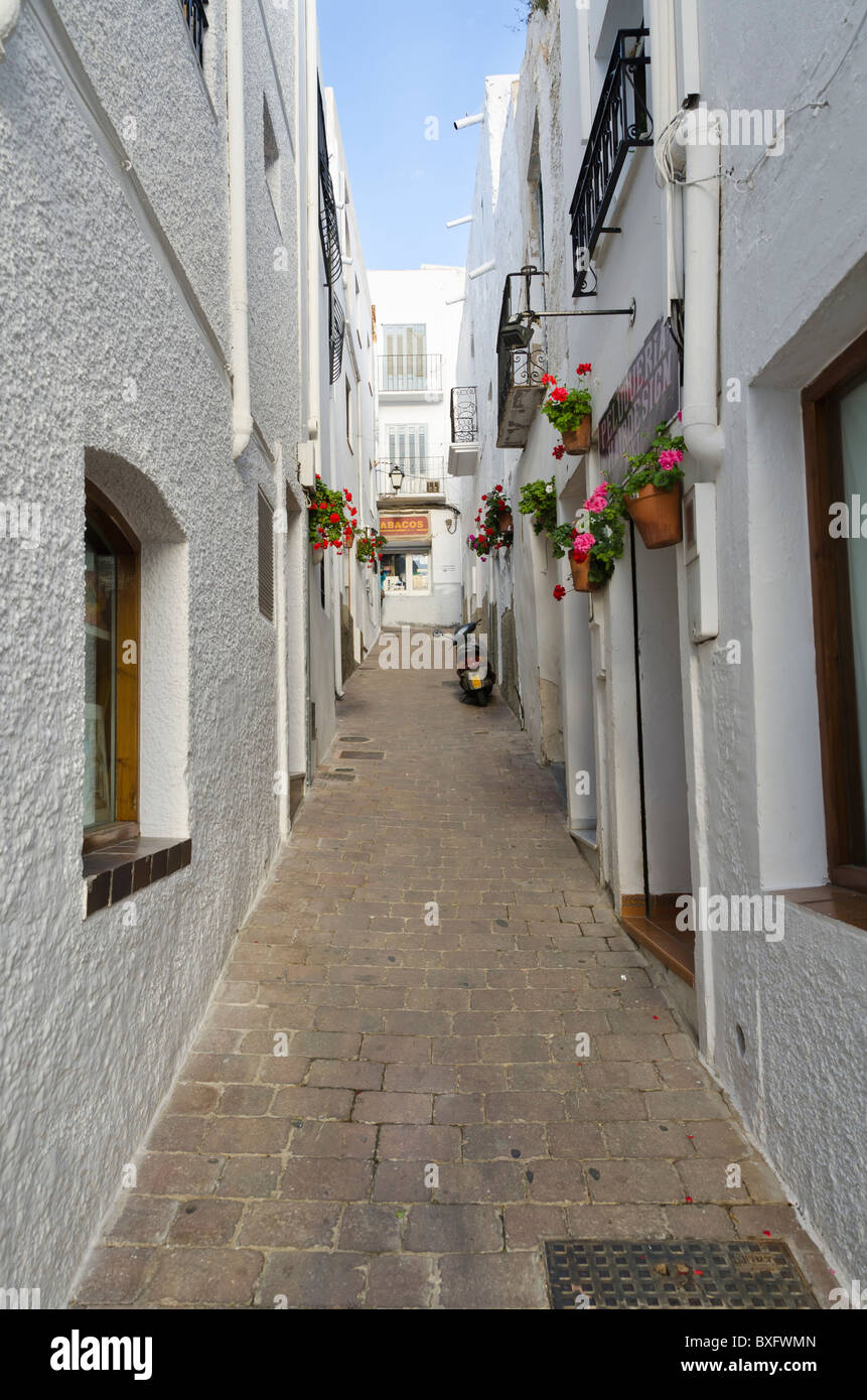 Une rue étroite à Mojacar, Almeria, Espagne. Une petite scène de rue Mojacar espagnol y compris un scooter à l'extérieur de maisons blanches avec des Géraniums. Banque D'Images