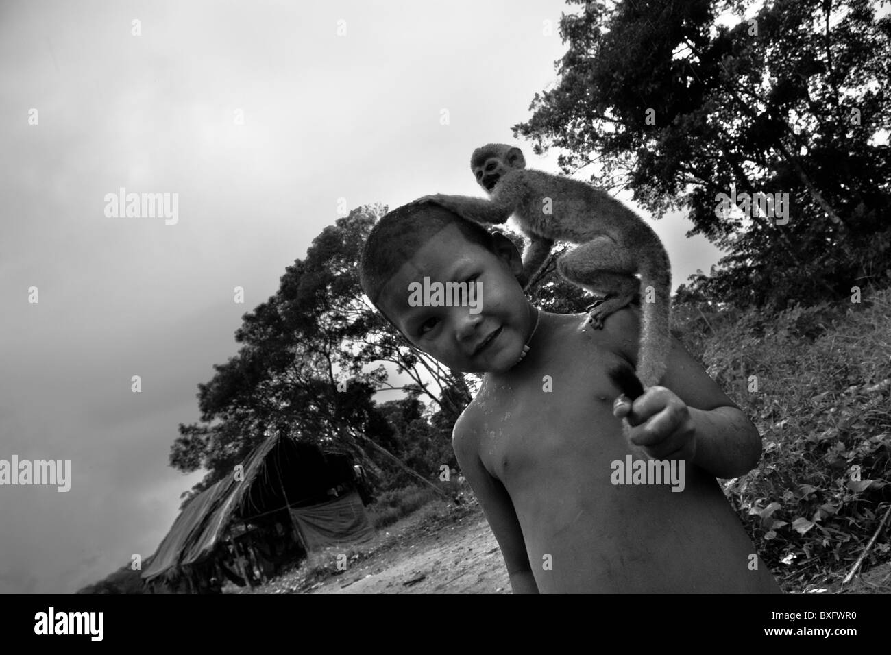 Un jeune indien déplacées (nukak maku) joue avec son animal singe dans un camp de réfugiés près de San Jose del Guaviare, en Colombie. Banque D'Images