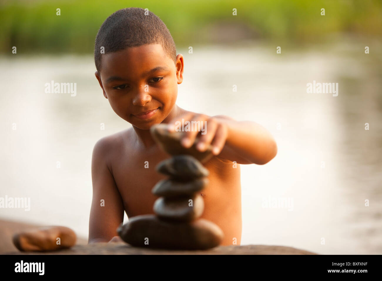 African American boy stacking rocks Banque D'Images