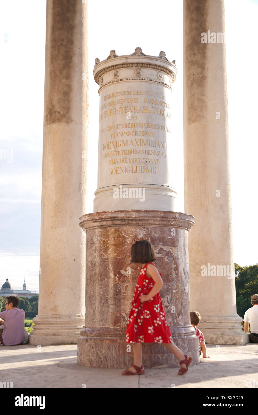 Fille d'une promenade dans un temple dans le parc anglais de Munich, en Allemagne. Banque D'Images