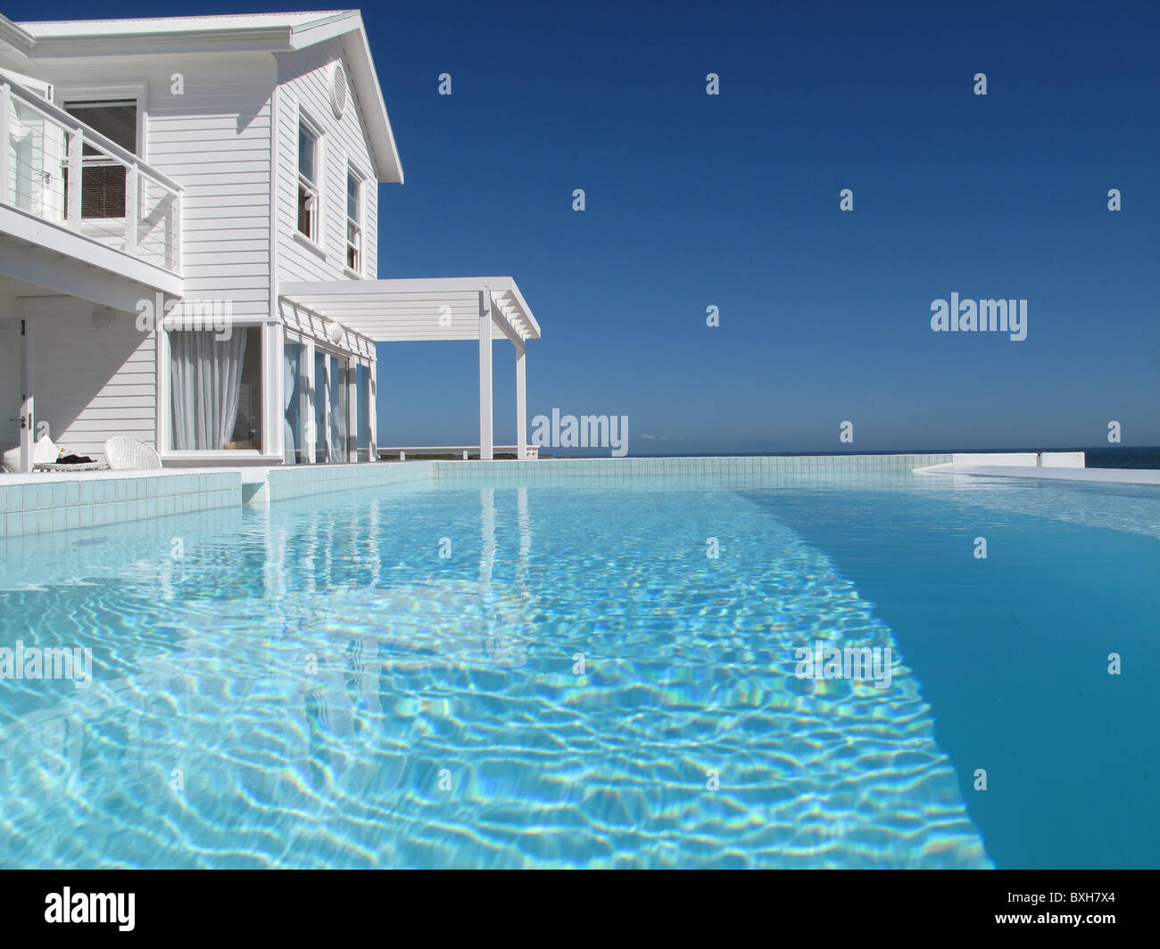Maison front de mer en bois blanc vue de la piscine à débordement Banque D'Images