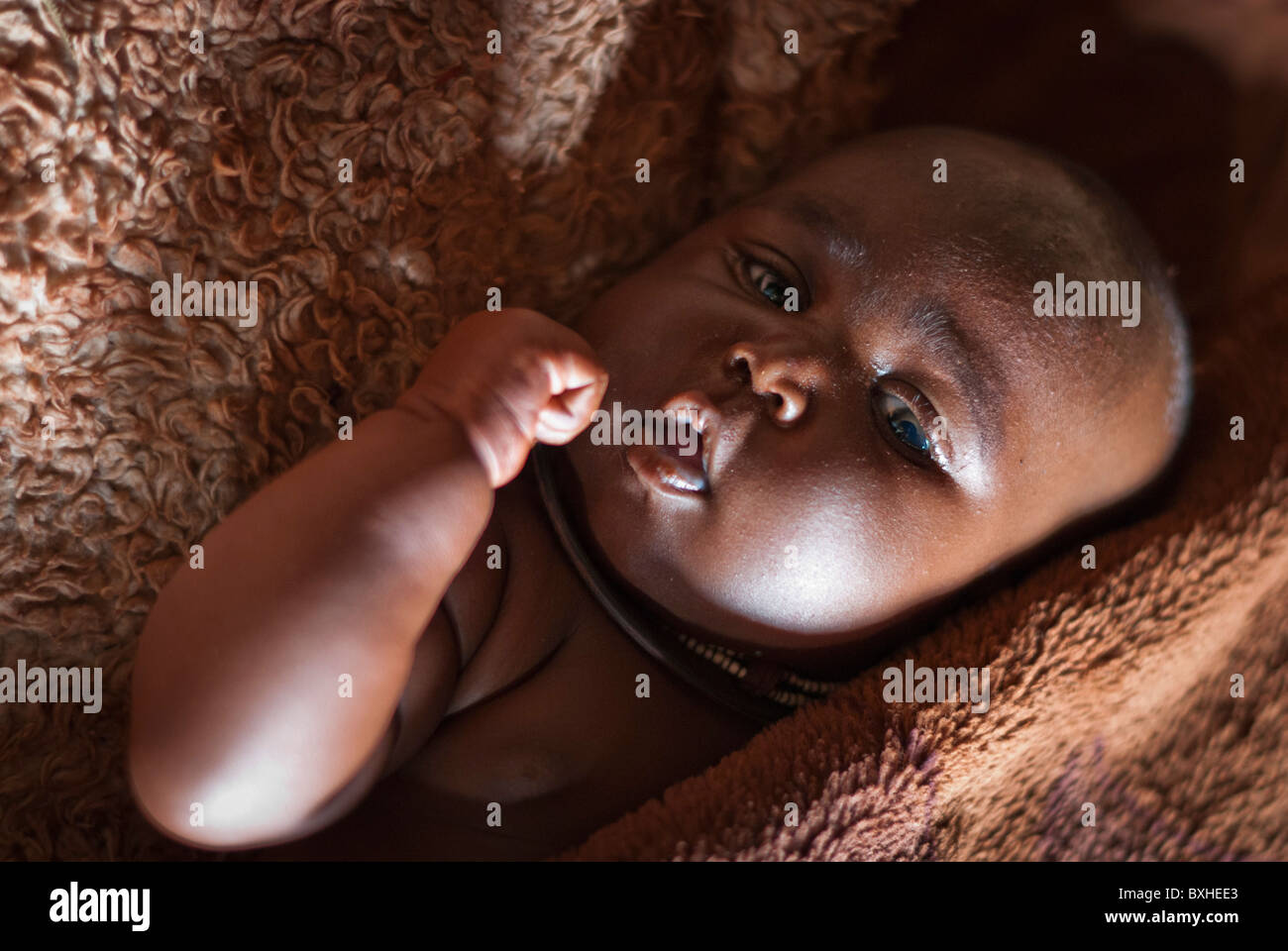 Himba bébé enveloppé dans une couverture. Près d'Epupa Falls, Kunene, Namibie, Afrique. Banque D'Images
