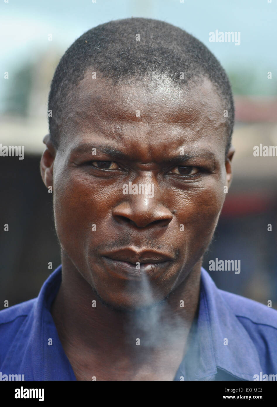 L'homme exhale la fumée, Côte d'Ivoire Banque D'Images
