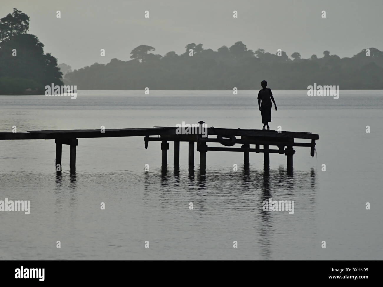 Silhouette de garçon sur la jetée de Sassandra, Côte d'Ivoire Banque D'Images