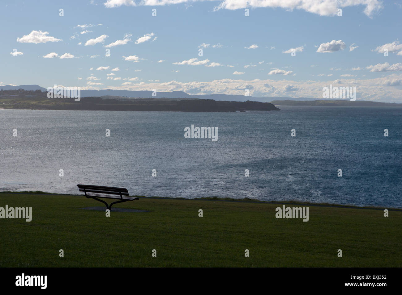 Banc vide singulier surplombant Ocean symbolisant la liberté / seul / isolement. Campbelltown NSW, Australie. Banque D'Images