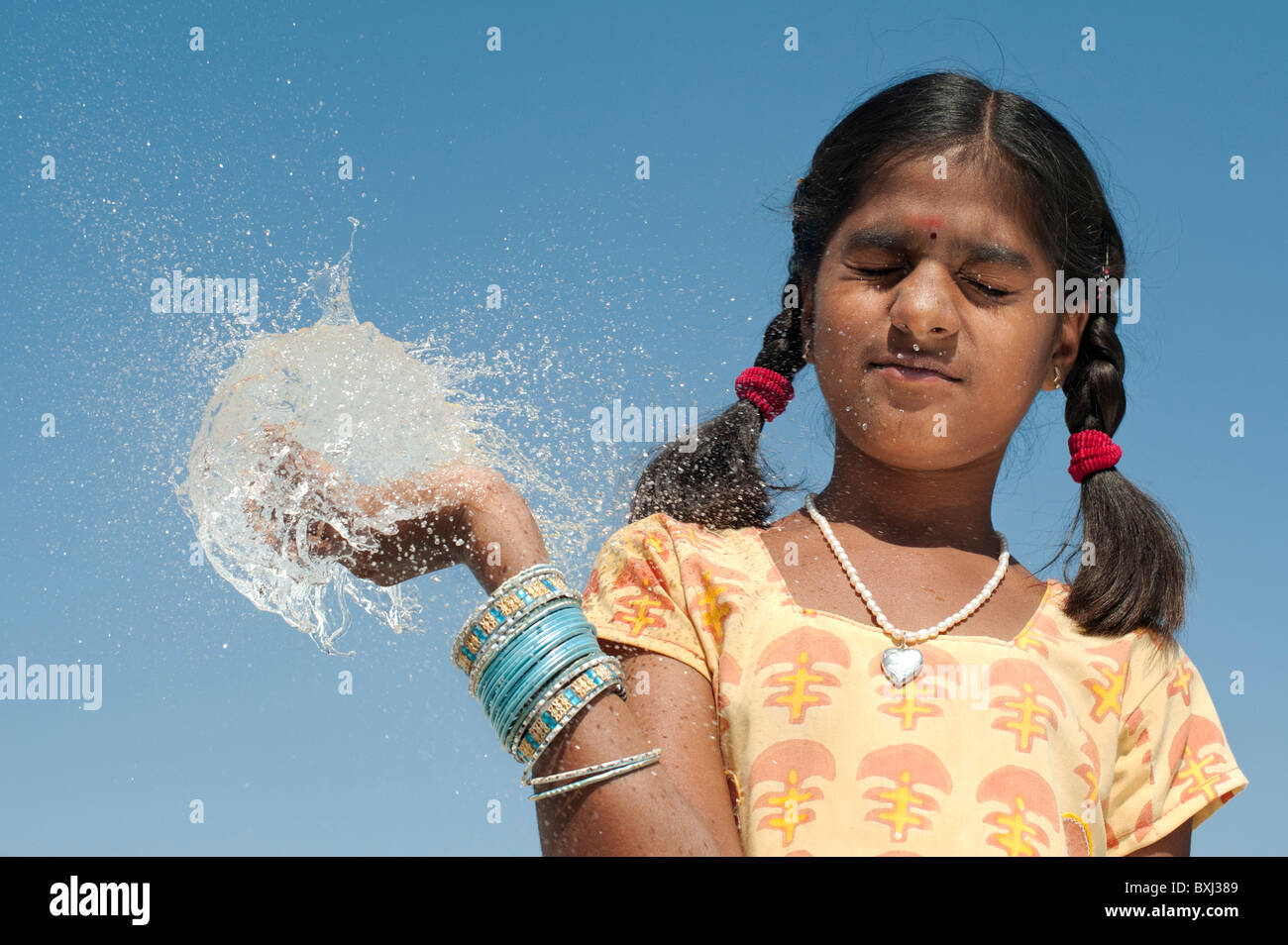 Indian girl tenant à la main un ballon d'eau burst ronde. L'Inde Banque D'Images