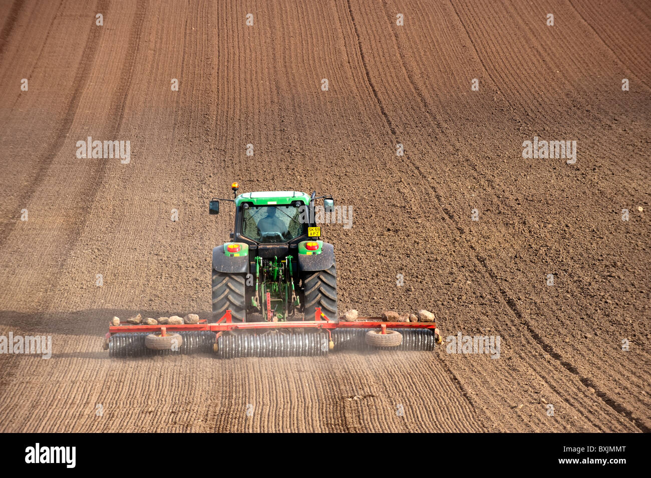 Appuyez sur le sol avec l'agriculteur, à l'aide de semence Matériel roulant tracteur John Deere. Kelso, Ecosse Banque D'Images