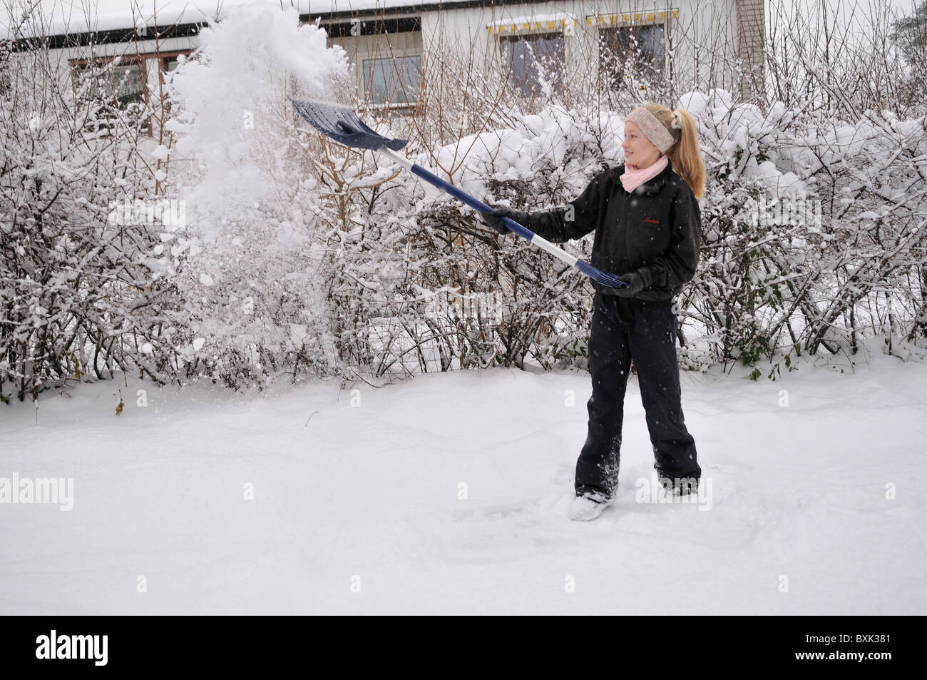 Yong girl pelleter la neige. Banque D'Images