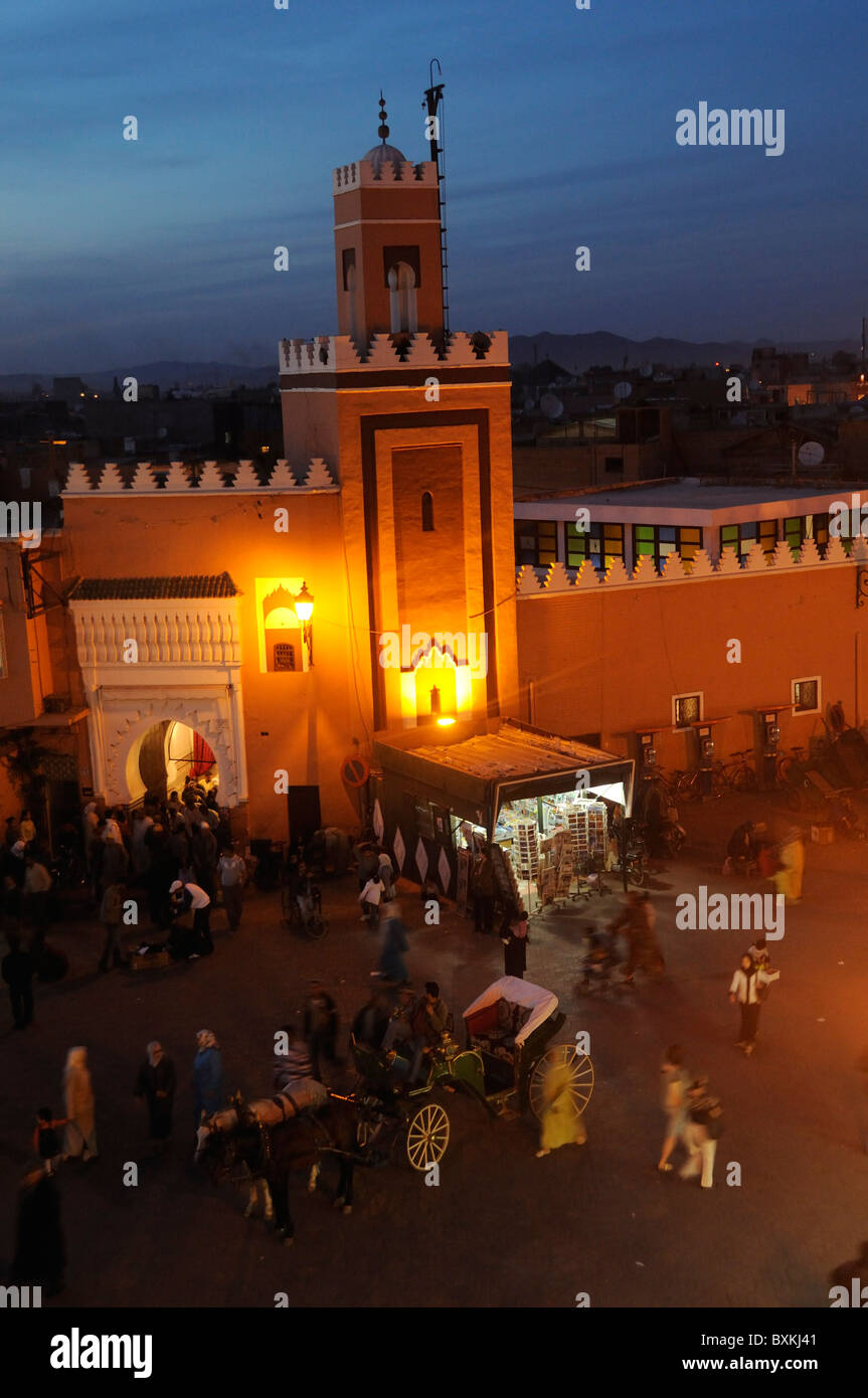 Mosquée et occupé la place Djemaa el-Fna lieu de rencontre dans la nuit à Marrakech Banque D'Images
