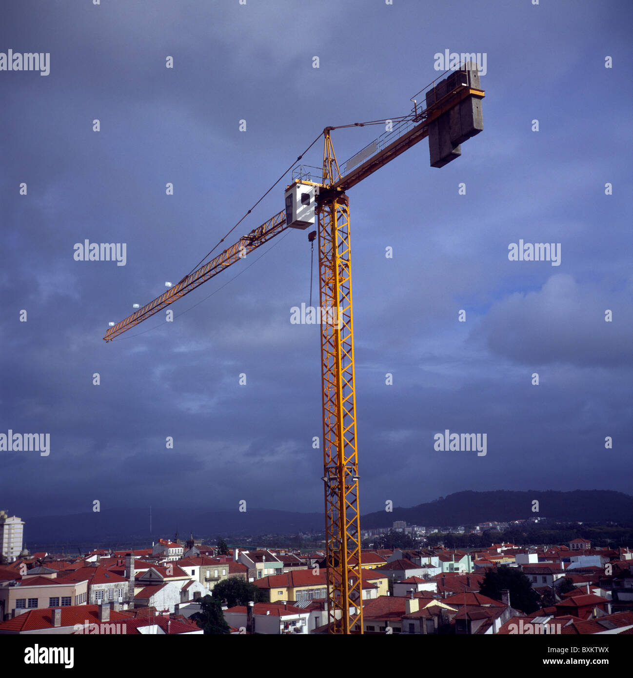 Grand tall crane haut au-dessus de maisons contre ciel d'orage Viana do Castelo, Portugal Banque D'Images