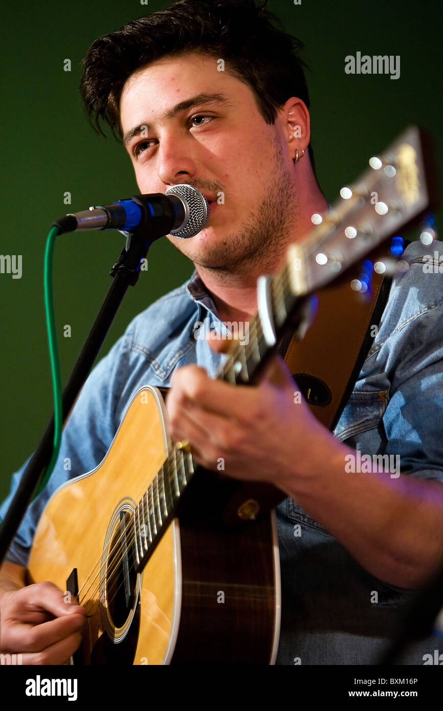 Marcus Mumford chantant une chanson et en jouant de la guitare pendant un concert de Mumford and Sons Banque D'Images