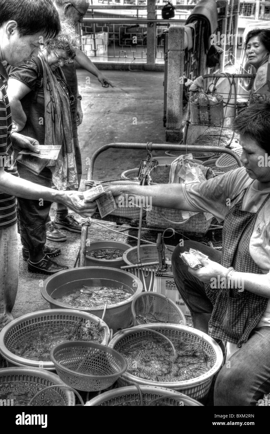 Tai O, Lantau Island, Hong Kong, Chine, Asie, Chines man acheter des poissons vivants à partir de la dame sur market stall Banque D'Images