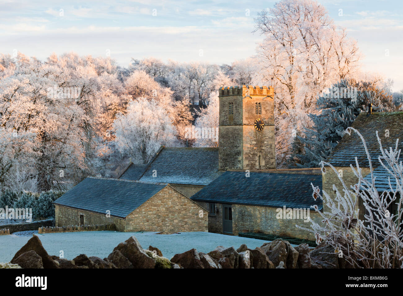 Le coucher du soleil sur l'église St Andrews dans le givre de la houar a couvert le village de Cotswold de Coln Rogers, Gloucestershire Royaume-Uni Banque D'Images