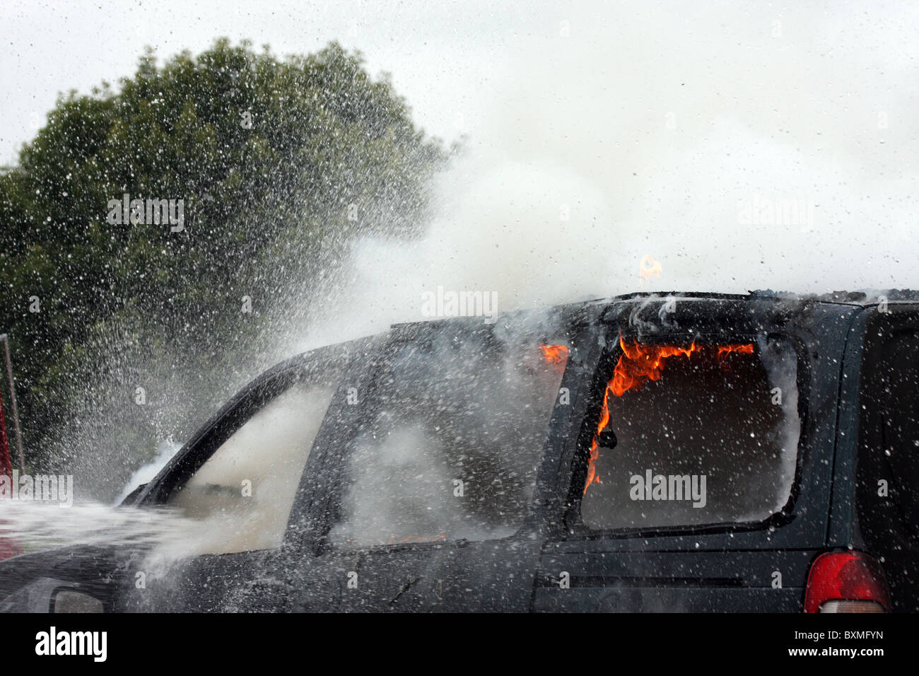 Une voiture avec des flammes de feu et de vapeur de l'eau pulvérisée Banque D'Images