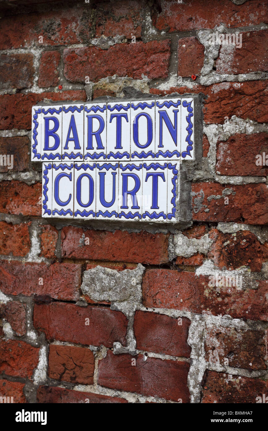 Un signe composé de carreaux de céramique émaillés individuels attachés à un mur de brique rouge. Le mortier a été réparé mal. Banque D'Images