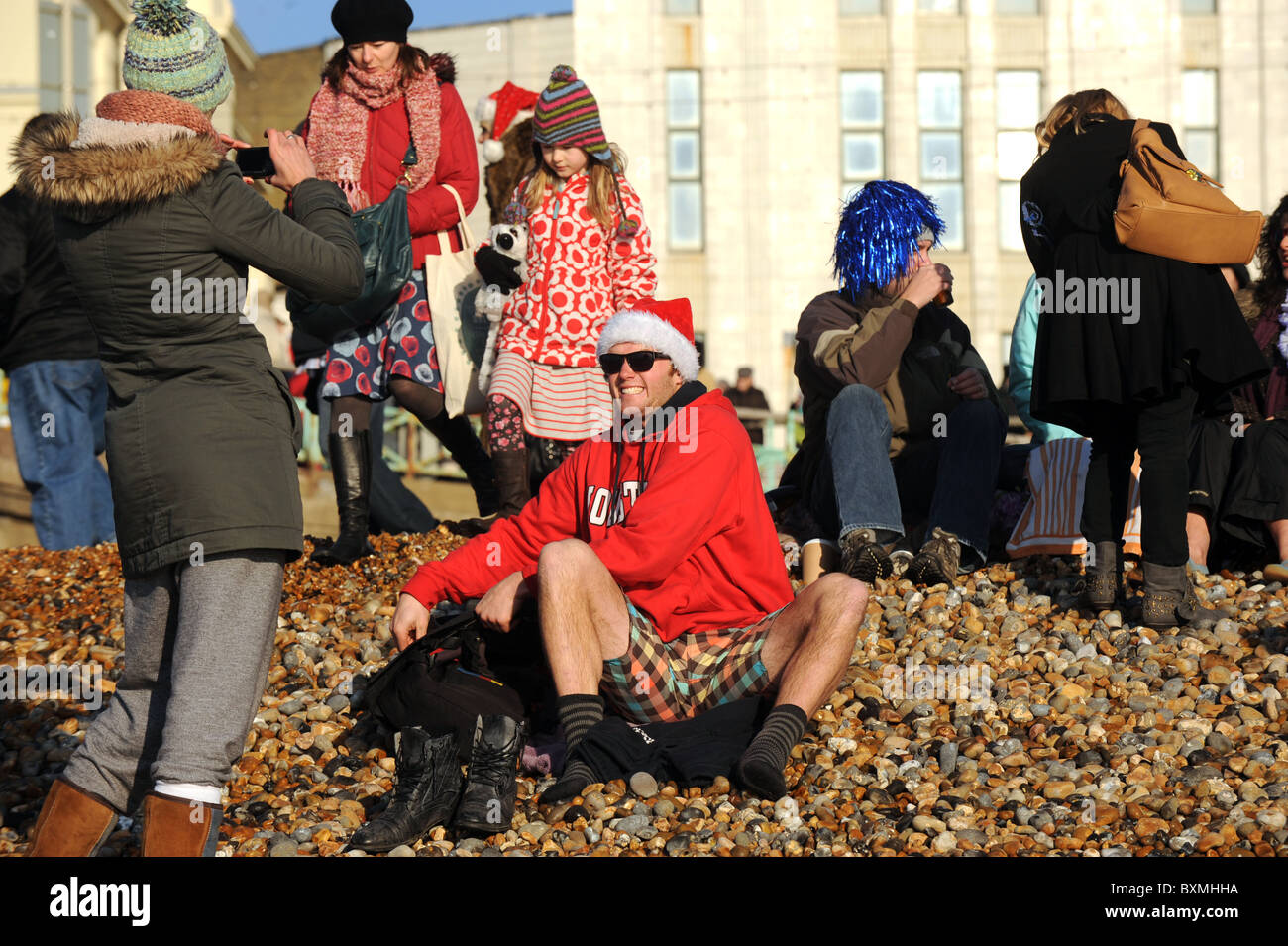 Des centaines de personnes se rassemblent sur la plage de Brighton à surveiller et prendre part à la Journée annuelle de Noël nager Banque D'Images