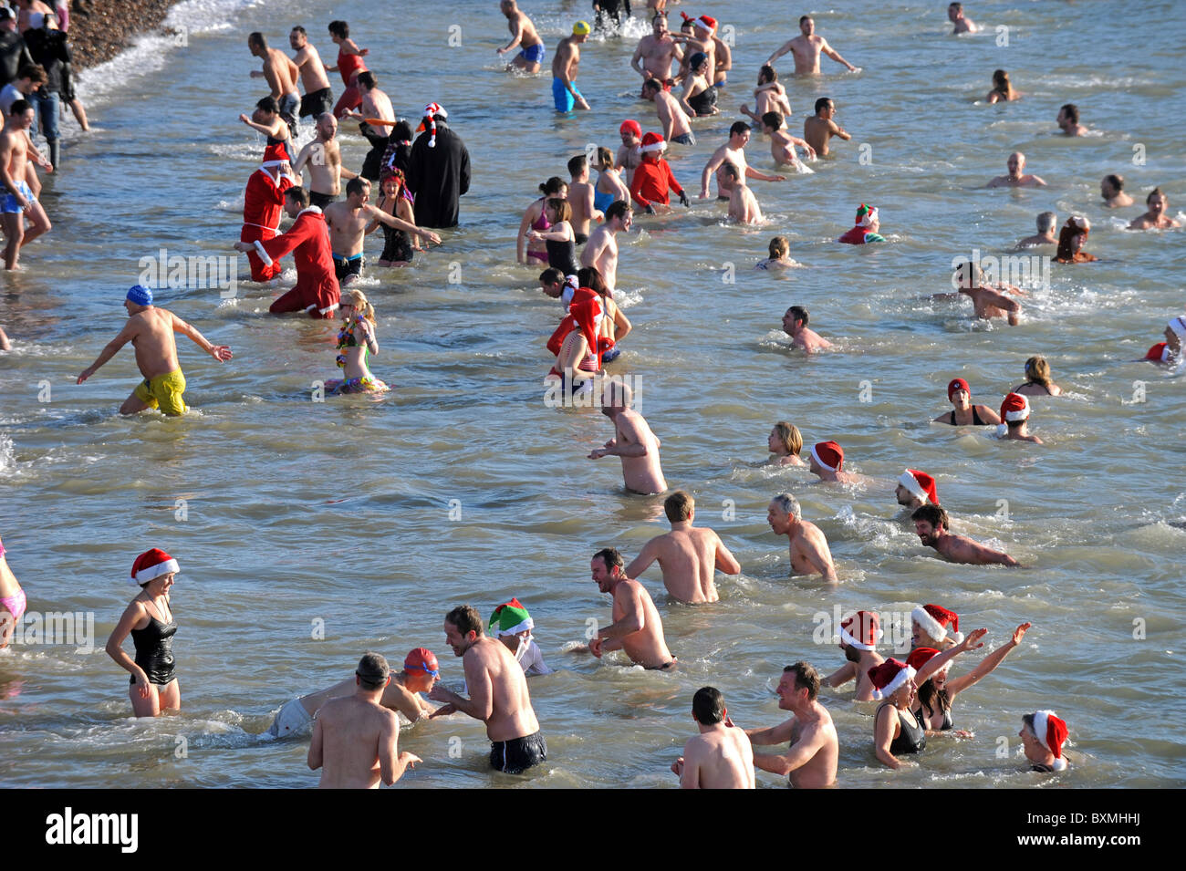 Des centaines de personnes se rassemblent sur la plage de Brighton à surveiller et prendre part à la Journée annuelle de Noël nager Banque D'Images