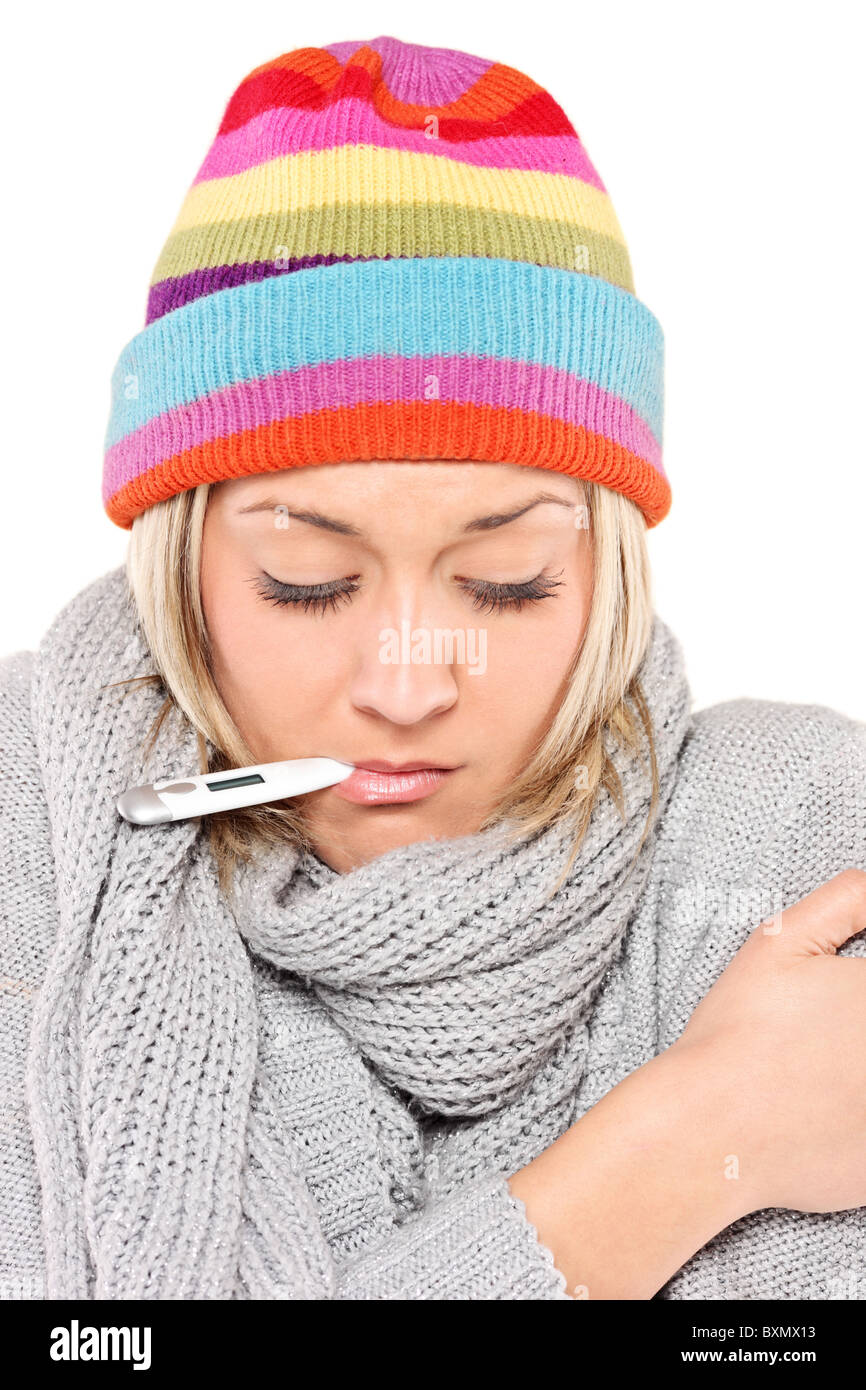 Femme malade portant une casquette et écharpe avec le thermomètre dans la  bouche Photo Stock - Alamy
