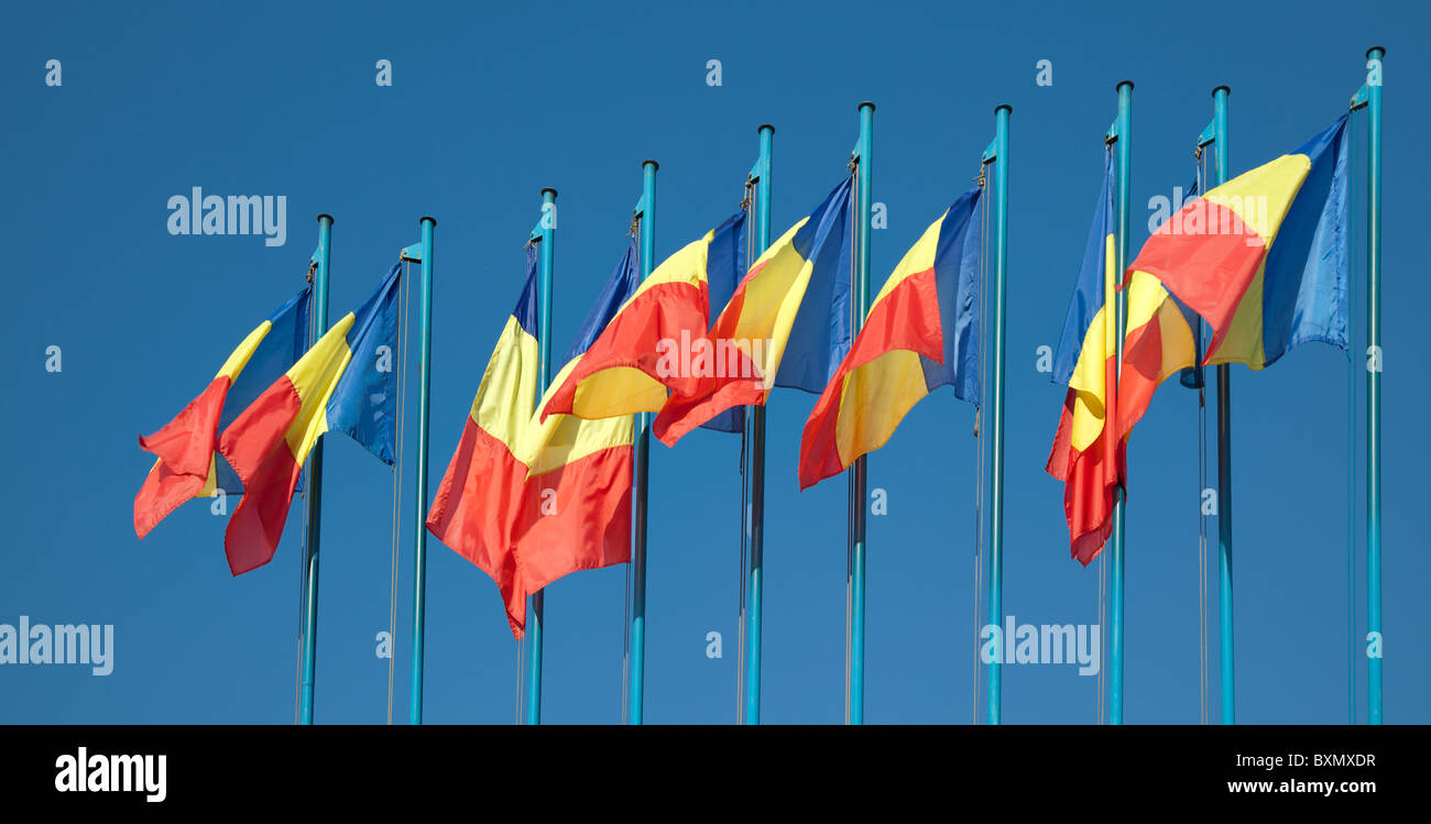 Rangée de drapeaux roumains contre le ciel bleu. Banque D'Images