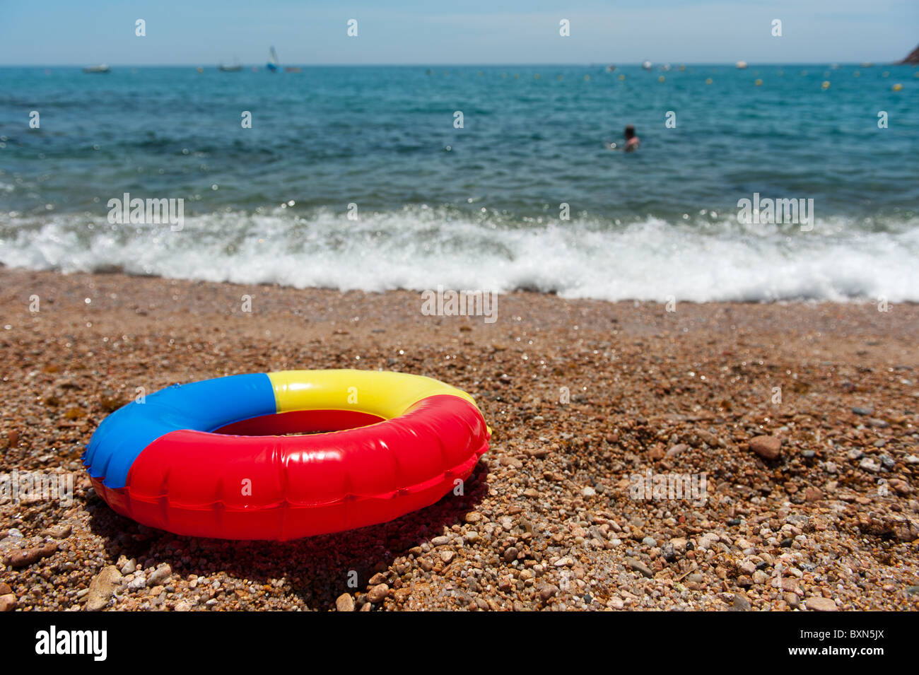 Toy life preserver en couleurs à la plage Banque D'Images