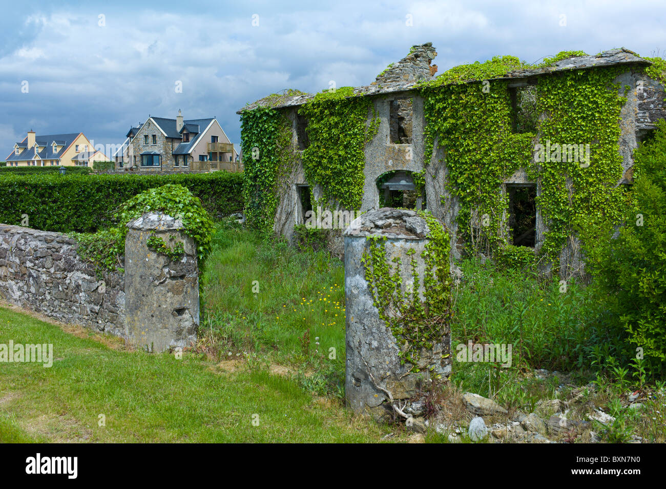 Nouveau contraste propriétés modernes à côté de vieille maison abandonnée dans le besoin de rénovation à Comté de Wexford, Irlande Banque D'Images