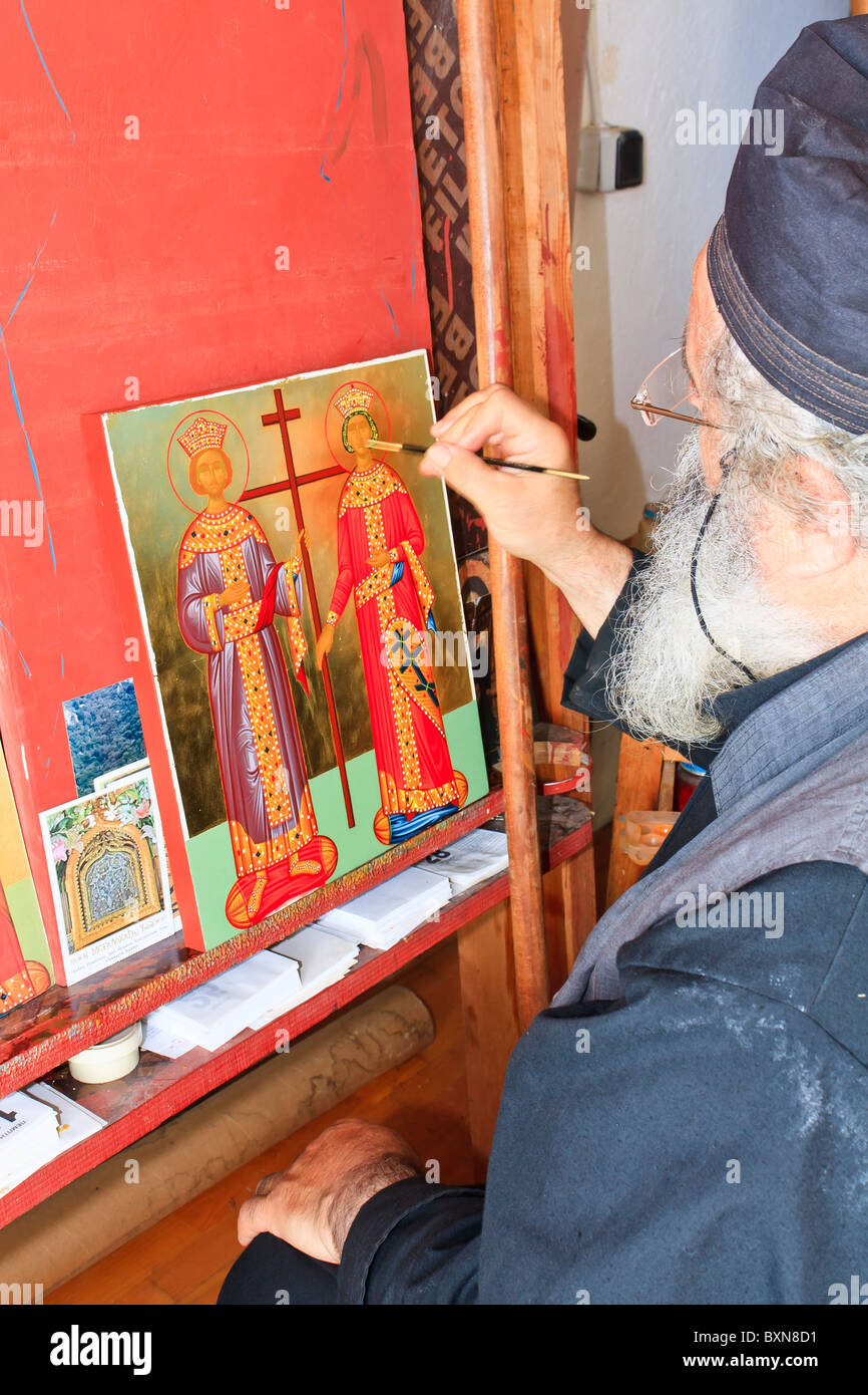 Personnes âgées prêtre peinture d'icône dans le monastère's studio Banque D'Images