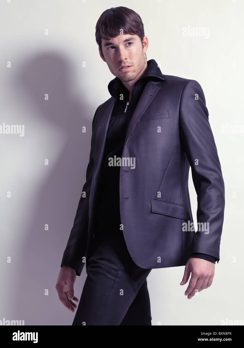 Fashion portrait d'un jeune homme vêtu d'un blazer noir isolé sur fond blanc Banque D'Images