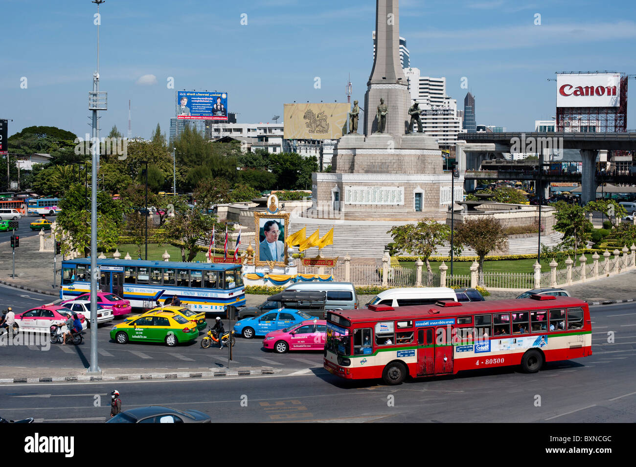 Les photographies et autres images du roi sont partout en Thaïlande, comme ici en face de Victoria Monument à Bangkok. Banque D'Images