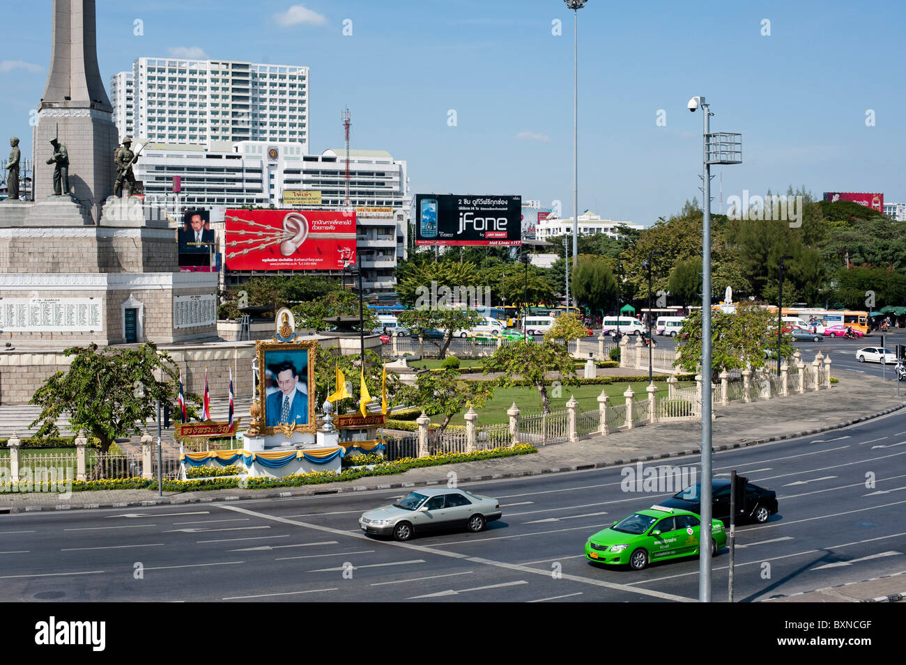 Les photographies et autres images du roi sont partout en Thaïlande, comme ici en face de Victoria Monument à Bangkok. Banque D'Images