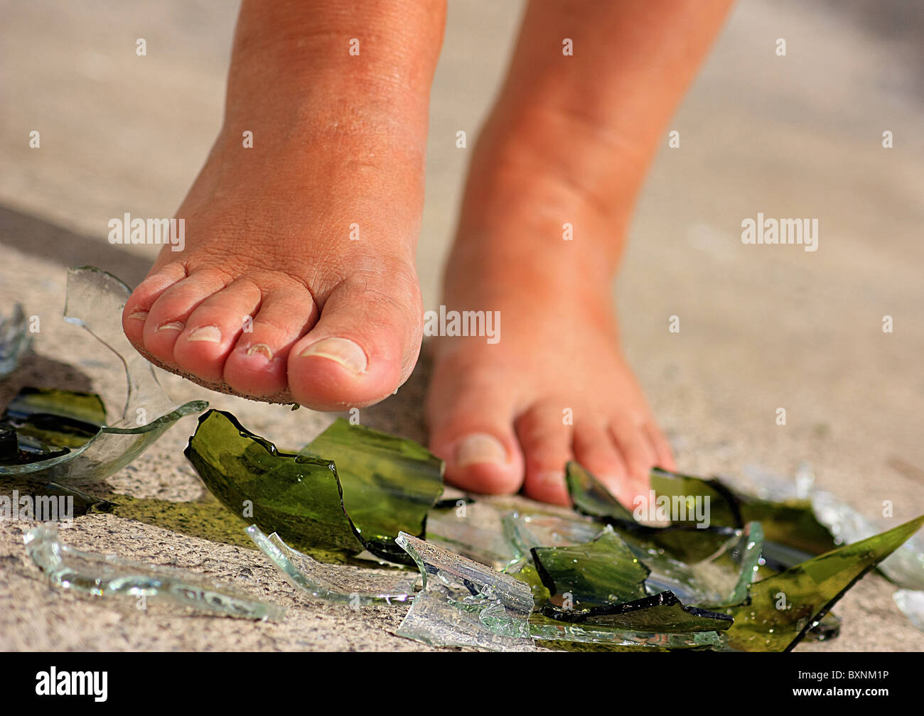 Femme marche sur des morceaux de verre dans les pieds nus Photo Stock -  Alamy