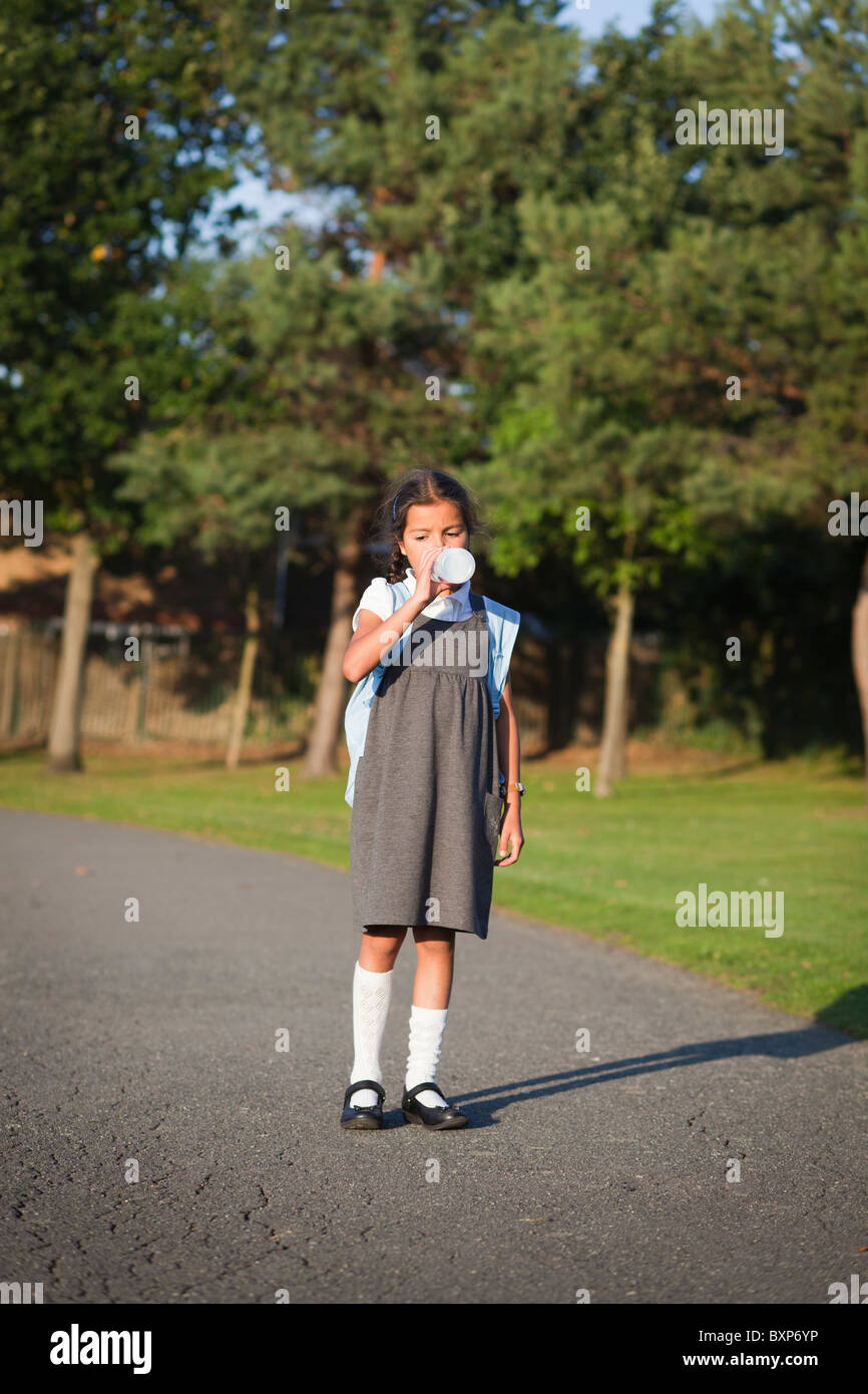 Fille qui marche à la maison de l'école Banque D'Images