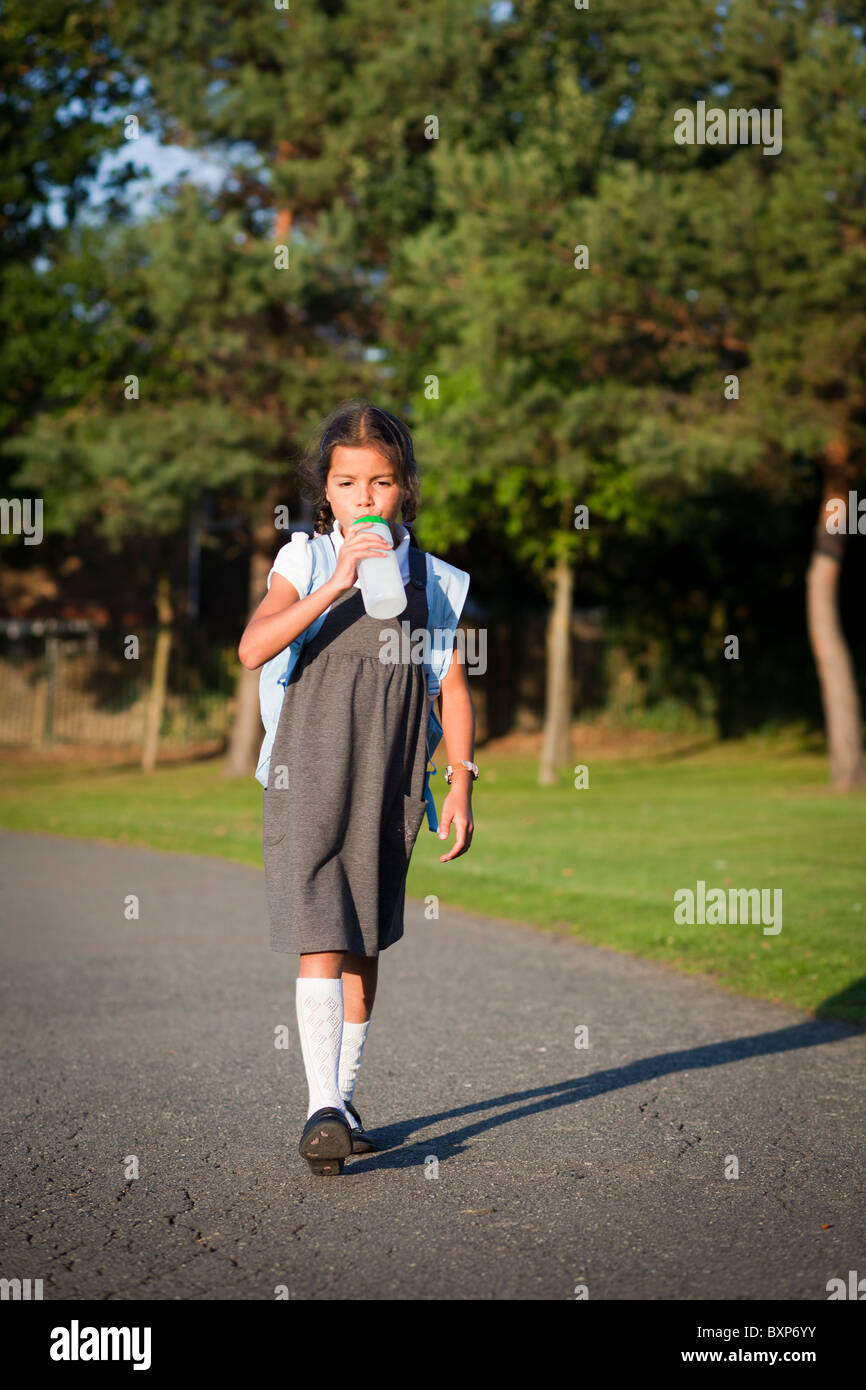 Fille qui marche à la maison de l'école Banque D'Images